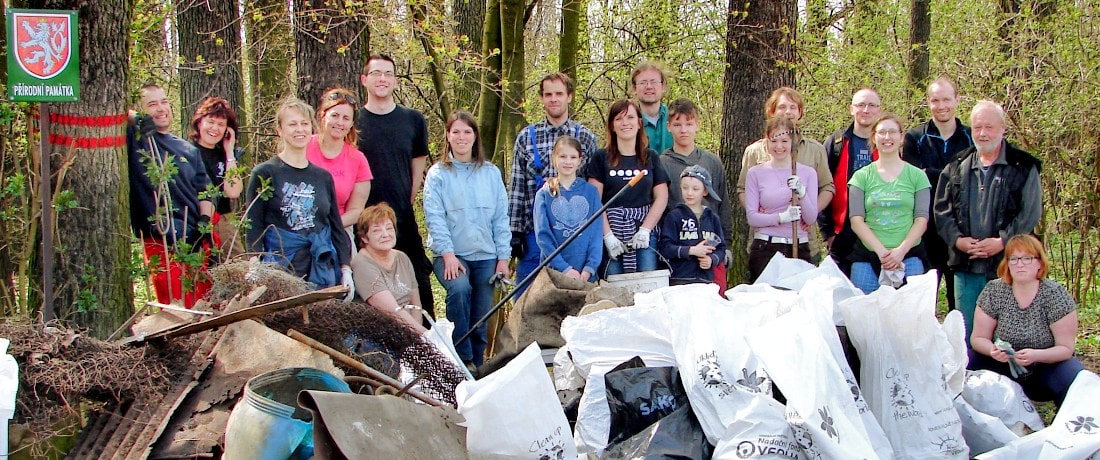 Skupina lidí se fotí s hromadou nasbíraných odpadků před přírodní památkou